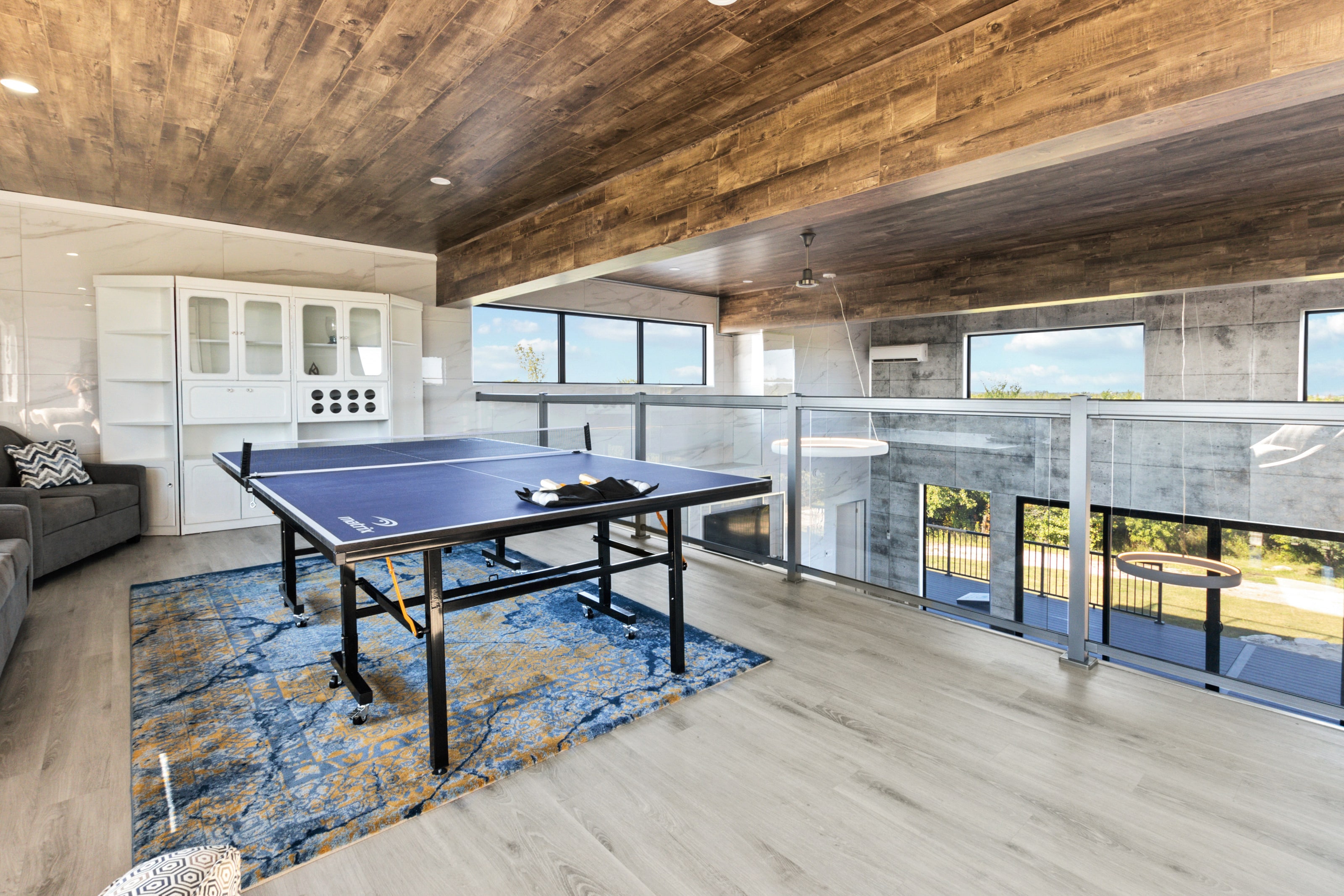 The loft table tennis area beside a glass balustrade looking down over the main floor