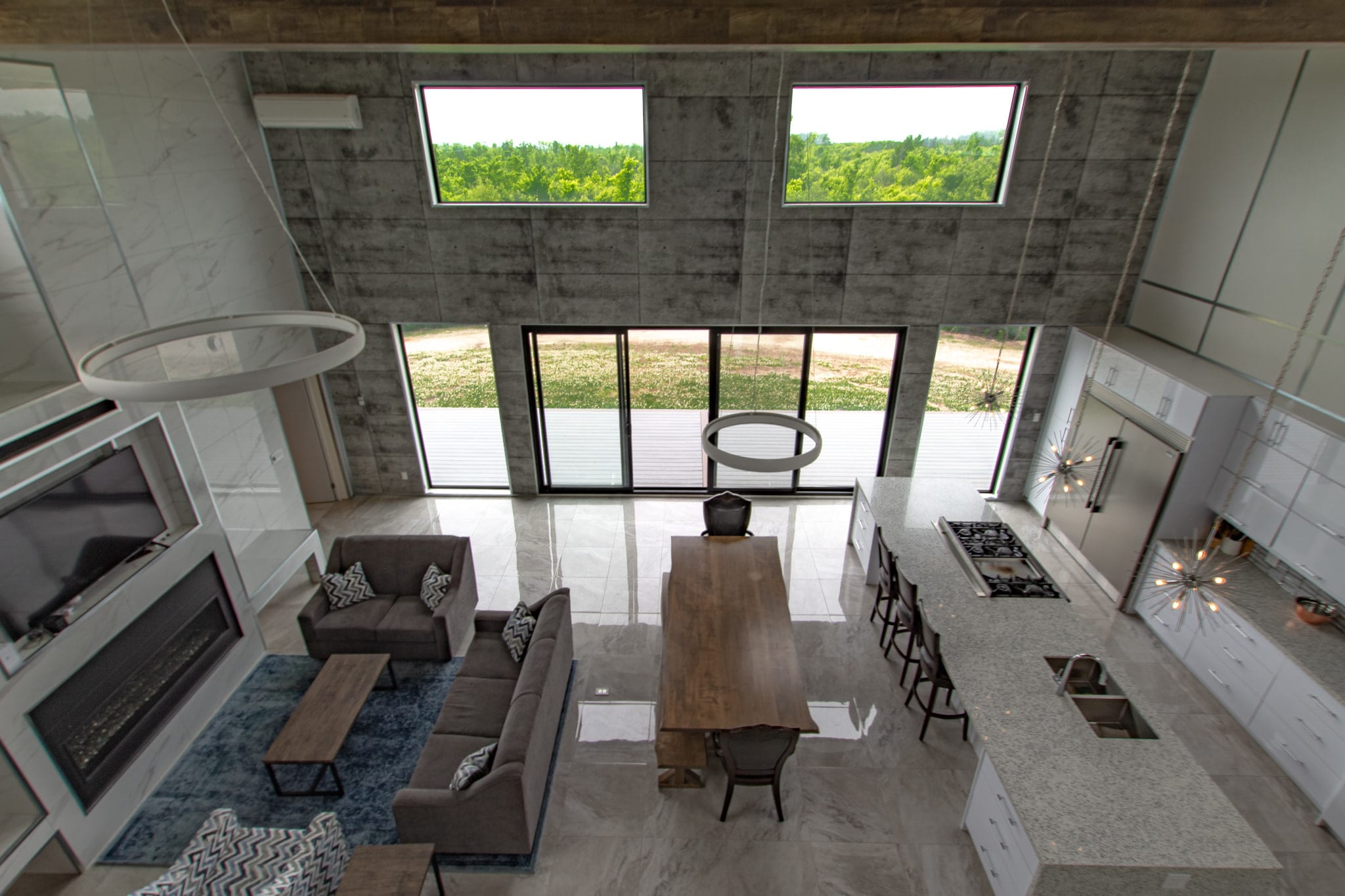 Looking down into the great room from the upper landing, over the fireplace, dining table and kitchen island