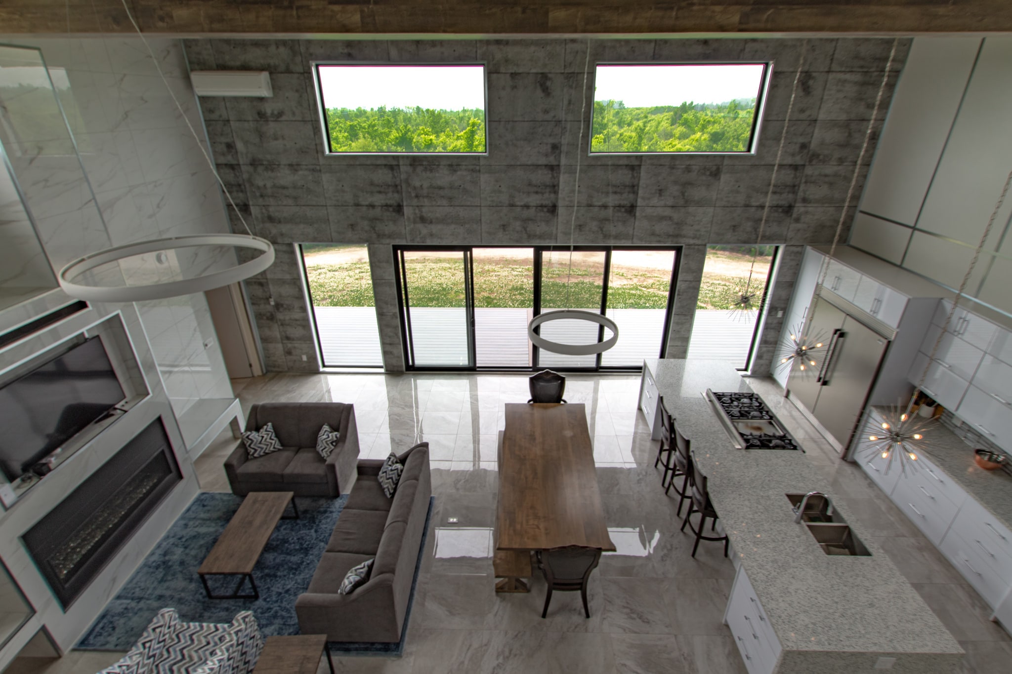 Looking down into the great room from the upper landing, over the fireplace, dining table and kitchen island